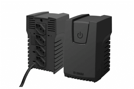 A imagem mostra um estabilizador de energia da marca TS Shara visto de dois ângulos. À direita, está a parte frontal do aparelho, em cor preta, com um botão de ligar/desligar redondo em destaque no centro superior. Abaixo do botão, aparece a marca TS SHARA gravada na carcaça. À esquerda, está a parte traseira do estabilizador, onde ficam as quatro tomadas de saída alinhadas verticalmente. Abaixo delas, sai o cabo de energia que conecta o equipamento à tomada. O design do estabilizador é robusto, com laterais cheias de aberturas para ventilação, garantindo maior segurança no uso.