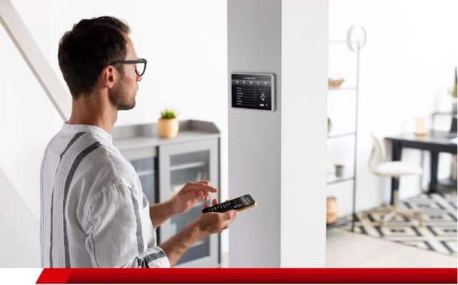 Homem controlando automação residencial por painel inteligente.