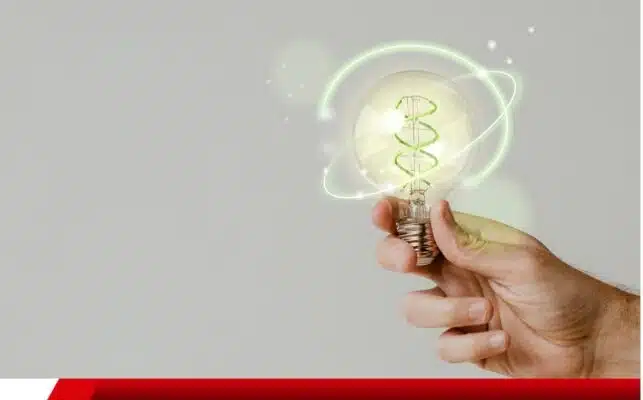 Mão segurando lâmpada com efeito de energia verde