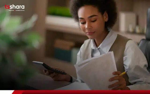 Mulher analisando documentos com calculadora na mão Perguntar ao ChatGPT