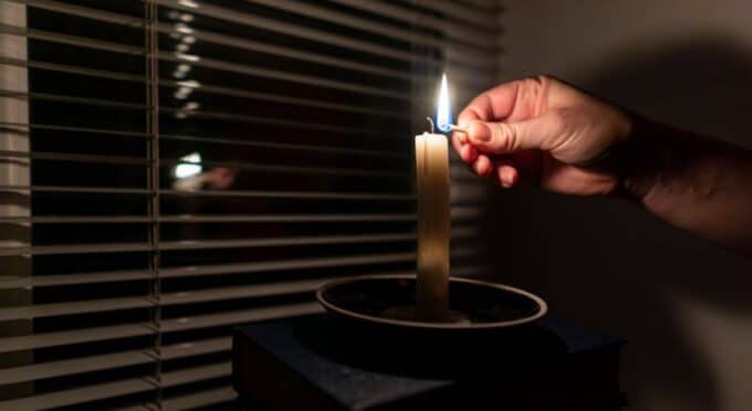 uma vela acesa em um quarto escuro 