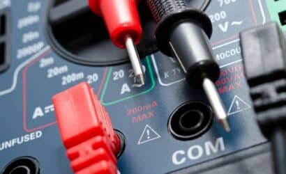 imagem de um multimetro de perto, com conectores vermelho e preto