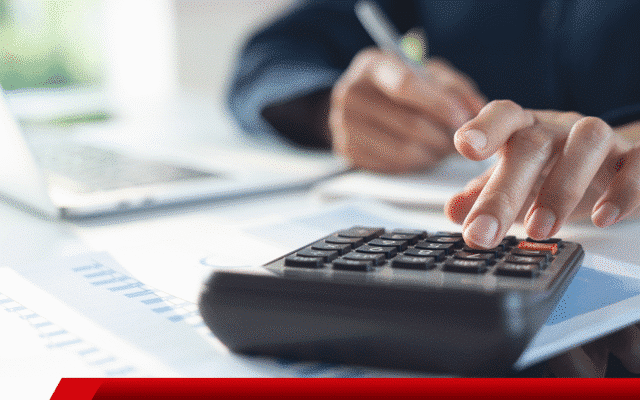 Pessoa fazendo contas com calculadora e anotações.