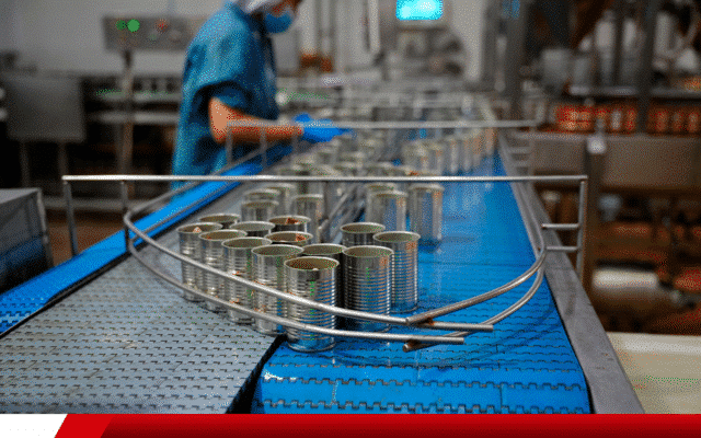 Linha de produção industrial com latas metálicas em esteira automatizada