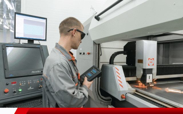 Técnico operando máquina de corte a laser com controle digital em indústria