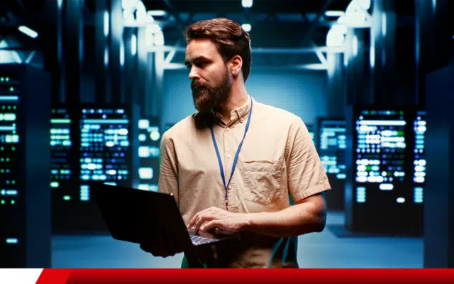 Técnico de TI monitorando servidores em data center.