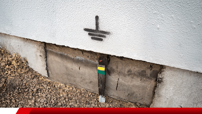 Haste de aterramento elétrico instalada no solo junto à edificação.